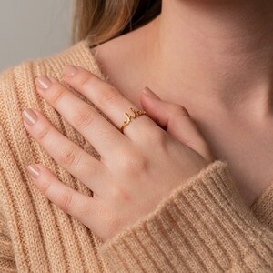 May include: A gold ring with the word "Chloe" written in cursive script.