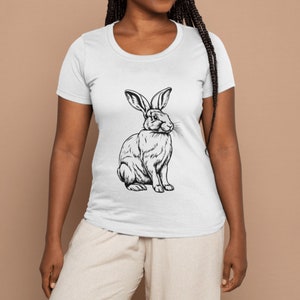 May include: A white t-shirt with a black and white line drawing of a rabbit on the front.