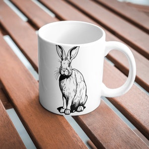 May include: White ceramic mug with a black and white illustration of a rabbit on the front.