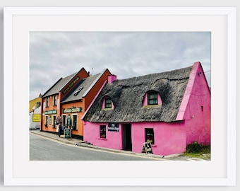 May include: A pink cottage with a thatched roof and a sign that reads "The Sweet Shop" in front of a yellow building with a sign that reads "Village Crafts".