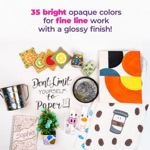 May include: A flat lay of various craft supplies, including a notebook with the word "Sophia" on the cover, a small potted plant, a metal cup, a set of coasters with fruit designs, a glass with a pig design, a glass with a duck design, a small plate with a black and white design, a tote bag with a geometric design, a tote bag with a coffee cup design, and a sign that says "Don't Limit Yourself to Paper".
