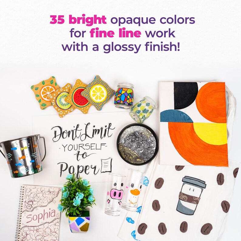 May include: A flat lay of various craft supplies, including a notebook with the word "Sophia" on the cover, a small potted plant, a metal cup, a set of coasters with fruit designs, a glass with a pig design, a glass with a duck design, a small plate with a black and white design, a tote bag with a geometric design, a tote bag with a coffee cup design, and a sign that says "Don't Limit Yourself to Paper".