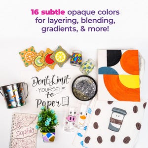 Puede incluir: Una colecci&oacute;n de art&iacute;culos pintados que incluyen una bolsa de mano con formas geom&eacute;tricas, una taza con un dise&ntilde;o de taza de caf&eacute;, un vaso con un dise&ntilde;o de cerdo, un contenedor de metal con dise&ntilde;os de peces, una libreta con la palabra "Sophia" en la portada, una peque&ntilde;a planta en maceta y un letrero que dice "No te limites al papel".