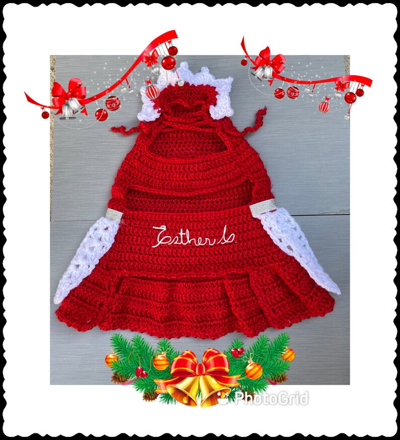 Puede incluir: Vestido de beb&eacute; de crochet rojo con ribete de encaje blanco y una corona de crochet blanco. El vestido tiene un dobladillo con volantes y el texto "Esther Is" bordado en la parte delantera.