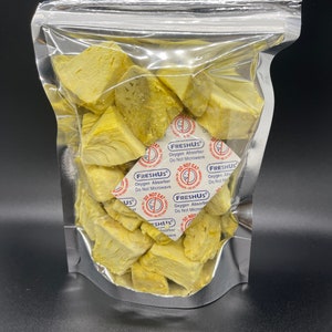 May include: A clear plastic bag filled with yellow jackfruit pieces. The bag has a label that reads "FRESHUS Oxygen Absorber Do Not Microwave".