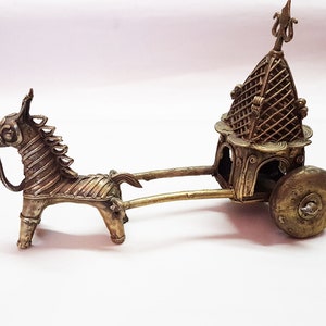 Peut inclure: Une sculpture en métal doré représentant un char tiré par un cheval. Le char est décoré de détails complexes et possède un petit toit orné. Le cheval se tient sur ses pattes arrière et a une crinière et une queue détaillées.