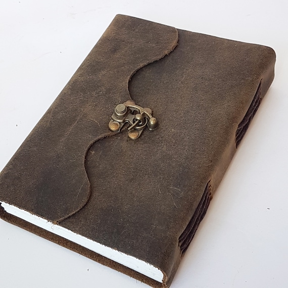 A hand-stitched leather grimoire with a bronze lock — looks like it was pulled from a wizard's shelf, not a factory.