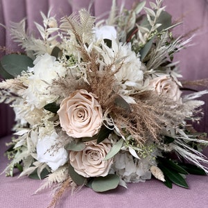 Beautiful loosely tied bridal bouquet Infinity roses. Bouquet of dried flowers. Bouquet.