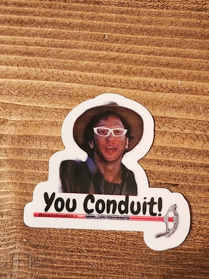 K&ouml;nnte beinhalten: Ein Aufkleber mit einem Mann, der einen Hut und eine Brille tr&auml;gt, mit dem Text "You Conduit!" und dem Benutzernamen "@sparkyminja613" darunter. Der Aufkleber enth&auml;lt auch ein rotes und schwarzes Werkzeug.