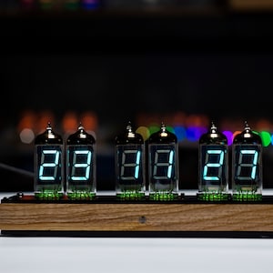 May include: A wooden clock with six Nixie tubes displaying the time as 28:28:28. The tubes are lit with a bright blue light.