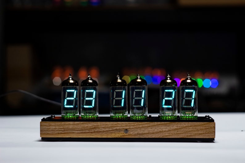 May include: A wooden clock with six Nixie tubes displaying the time as 28:28:28. The tubes are lit with a bright blue light.