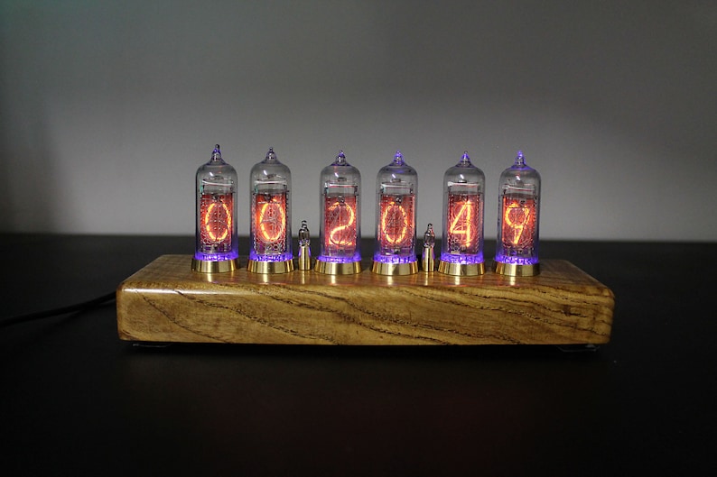 May include: A wooden clock with six clear glass tubes displaying the time as 002049. The tubes have orange glowing numbers and purple glowing lights at the bottom.
