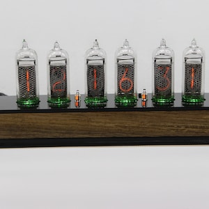 May include: A wooden clock with six clear glass tubes displaying the time as 12:16:31. The tubes have orange numbers and green accents.