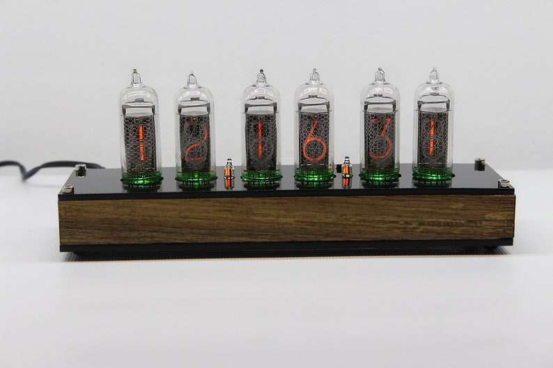 May include: A wooden clock with six clear glass tubes displaying the time as 12:16:31. The tubes have orange numbers and green accents.