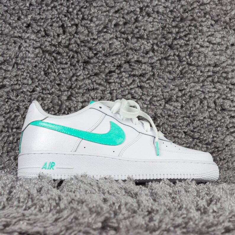 black nike shoes with teal swoosh