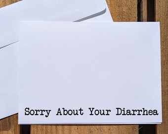 May include: A white card with the text "Sorry About Your Diarrhea" printed in black.