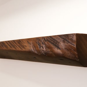 close up of a walnut live edge wooden floating shelf