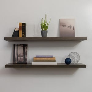 Two Aged Barrel Rustic Floating Shelves with Decorations on a White Wall