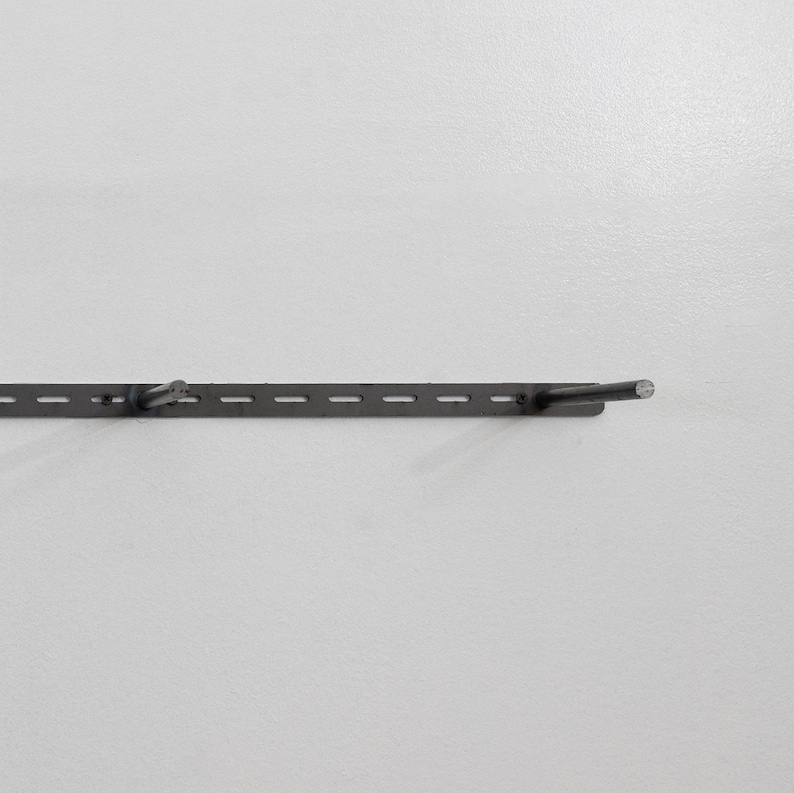Metal Floating Bracket on a wall secured with screws