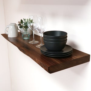 live edge walnut shelf with decorations on a wall