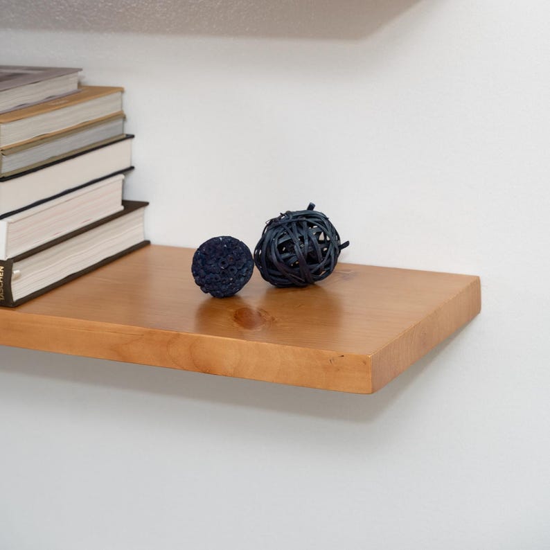 Wooden Aged Oak Floating Shelf on a Wall with Books and Decorations. Heavy duty shelf with floating bracket included.