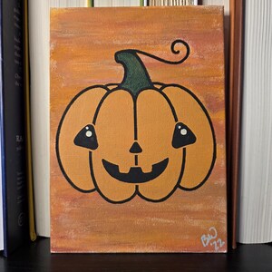 May include: A rectangular canvas painting featuring a central orange pumpkin with a black jack-o'-lantern face, a green stem, and a curly vine. The background is a textured orange and brown gradient. The artist's signature BW '22 is in the bottom right.