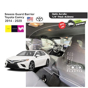 May include: A clear plastic sneeze guard barrier for a car, made of 1/4 inch thick acrylic. The barrier is installed in the back seat of a white Toyota Camry. The barrier has a sign that says "BOLD PLASTIC" on the back.