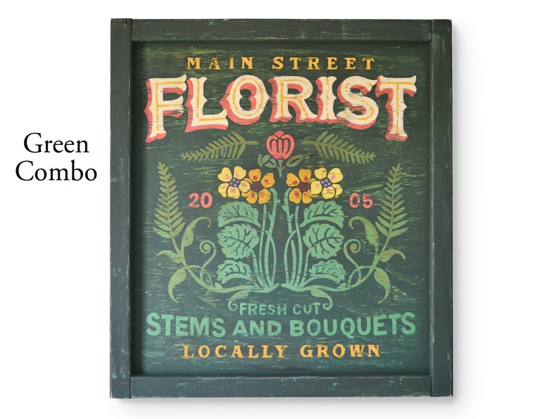 May include: A green wooden sign with the text "Main Street Florist" in a vintage font. The sign also features a floral design with yellow and pink flowers, green leaves, and the text "Fresh Cut Stems and Bouquets Locally Grown".