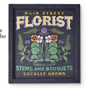 May include: A vintage-style sign with the text "Main Street Florist" in a decorative font. The sign is painted on a dark blue background with a floral design and the text "Fresh Cut Stems and Bouquets Locally Grown".