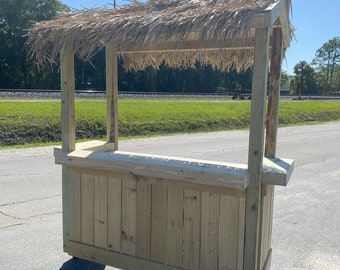 May include: A wooden tiki bar with a thatched roof, on wheels, for outdoor entertaining.