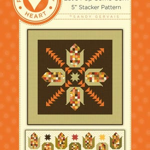 May include: A quilt pattern named "Let's Pop Some Corn" featuring a central design of corn cobs and starbursts, set against a brown and olive green backdrop. The text "5" Stacker Pattern" is visible.