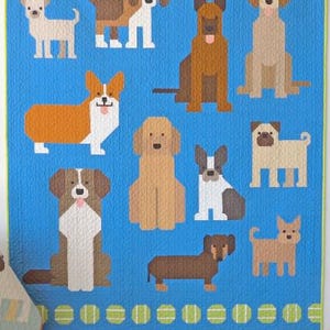 May include: A blue quilt with a border of green and yellow tennis balls. The quilt features a variety of dog breeds in a pixelated style, including a corgi, a dachshund, a pug, and a chihuahua.