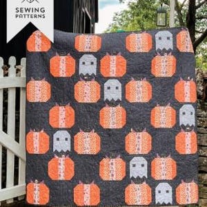 Peut inclure: Une courtepointe avec un motif répétitif de citrouilles orange et de fantômes gris clair sur un fond gris anthracite. L'image comporte le texte Melissa Sewing Patterns et Pumpkin Patch Ghosts Fat Quarter Friendly.