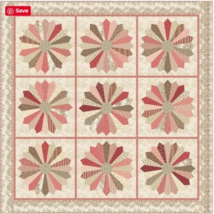 Könnte beinhalten: Ein handgefertigter Quilt mit neun großen, stilisierten Blumenmustern. Jede Blume hat einen Mittelkreis und strahlenförmige Blütenblätter in Rot-, Rosa- und Brauntönen. Der Quilt hat einen cremefarbenen Hintergrund und eine dekorative Bordüre.