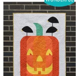 May include: A quilted wall hanging featuring a smiling jack-o'-lantern design. The pumpkin is orange and yellow with a green stem and black accents. The words "POSH Jack-O" and "Sew Kind of WONDERFUL" are visible. The background is white with a textured pattern.