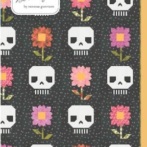 May include: A quilt pattern featuring a repeating design of white skulls and colorful flowers on a dark gray background. The flowers are pink, orange, and yellow. The text "Lella Boutique" and "Pushing Up Daisies" are visible.