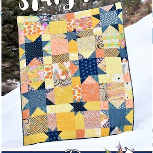 May include: A colorful quilt with a star pattern, featuring shades of yellow, orange, and navy blue. The quilt has a patchwork design with the word "Stargazer" at the top. The quilt is made by Running Doe Quilts for Villa Rosa Designs.