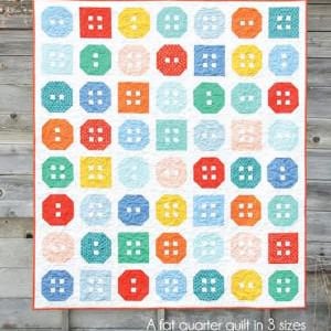 May include: A colorful quilt with a button design. The quilt features a grid of square and octagonal shapes in various colors, including red, yellow, blue, orange, and green. The text "Button Up" is at the top, and "A fat quarter quilt in 3 sizes" is at the bottom.