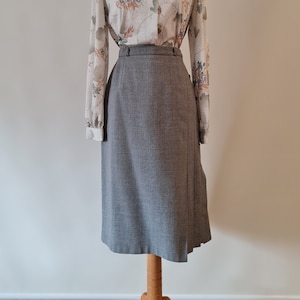 May include: A gray skirt with a wrap design and a floral print blouse with long sleeves.