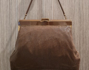 May include: A brown mesh clutch purse with a gold clasp and chain strap.