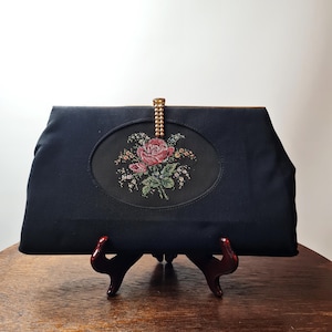 Bolso de mano de rayón negro de los años 50 de Clothfair of London con aplicación de petit point en la parte delantera. Fabricado en Gran Bretaña.