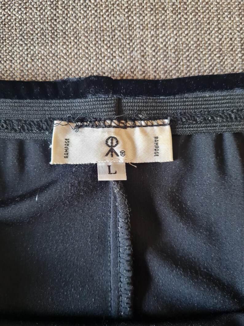 May include: Black pants with a black velvet waistband and a white tag that says "Rampage" and "L" on it.