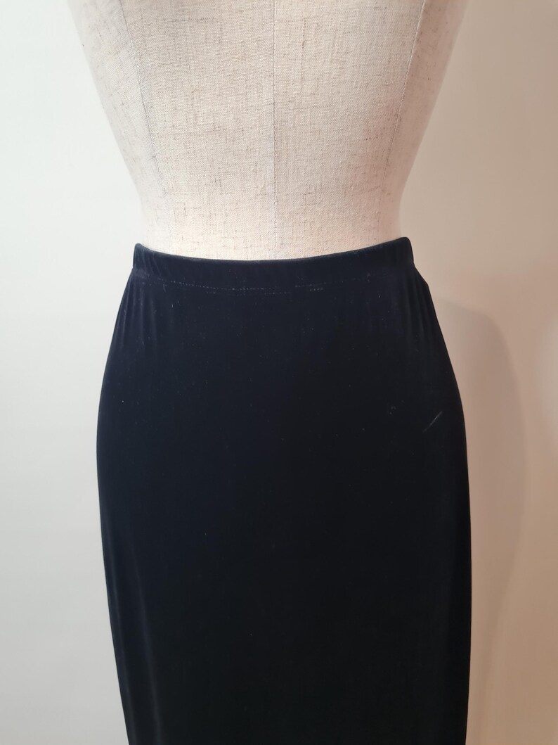 May include: A black velvet skirt with a straight silhouette.