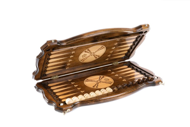 Puede incluir: Un juego de backgammon de madera con un acabado marr&oacute;n y tallas intrincadas. El juego est&aacute; abierto, revelando el tablero de juego y las piezas.