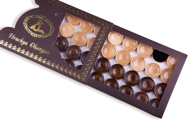 May include: A brown wooden box with a clear plastic window showing a set of draughts. The draughts are in two colours: light brown and dark brown. The box has a gold border and the text "Hrachya Ohanyan" is printed on the front.