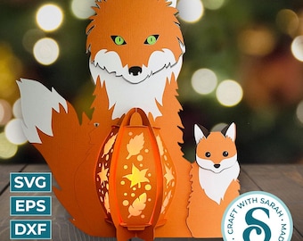 Könnte beinhalten: Eine Papierlaterne mit einem Fuchsdesign. Die Laterne ist orange und weiß und hat ein ausgeschnittenes Design aus Blättern und Sternen. Die Laterne ist von zwei Füchsen umgeben, einem großen und einem kleinen. Die Füchse sind orange und weiß und haben grüne Augen. Die Laterne ist ein 3D-Design und kann zusammengebaut werden.