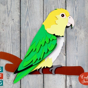 May include: A papercraft parrot with green, yellow, and white feathers perched on a brown branch. The parrot is facing right and has a yellow head with a black eye. The background is a gray woodgrain texture. "Craft with Sarah" is written in red on a white circle in the lower right corner.