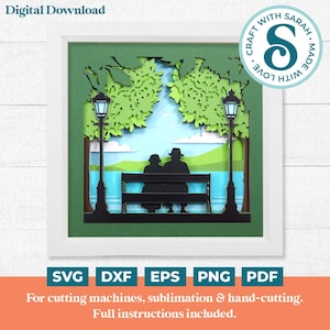 以下が含まれることがあります： 木の下のベンチに座っているカップルと2本の街灯が描かれた、重ねて作るペーパークラフトのデザインのデジタルダウンロードです。デザインは緑と白のフレームで囲まれています。画像の右上には円の中に「Craft with Sarah. Made with Love.」というテキストがあります。