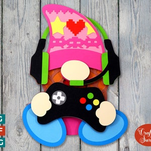 May include: A pink and white gnome wearing a headset and holding a black video game controller. The gnome has a heart and star design on its hat.