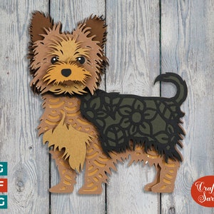 Könnte beinhalten: Ein Papierbastel-Design eines Yorkshire-Terriers mit braunem und schwarzem Fell. Der Hund steht auf einem Holzmaserungshintergrund. Das Design ist aufwendig und detailliert, mit einem Blumenmuster auf dem Rücken des Hundes.
